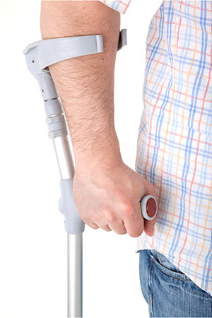A man's arm holding a crutch