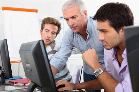 Three men looking at a computer screen