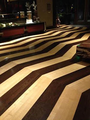 A floor with a high contrast wavy pattern that gives the impression of an undulating surface