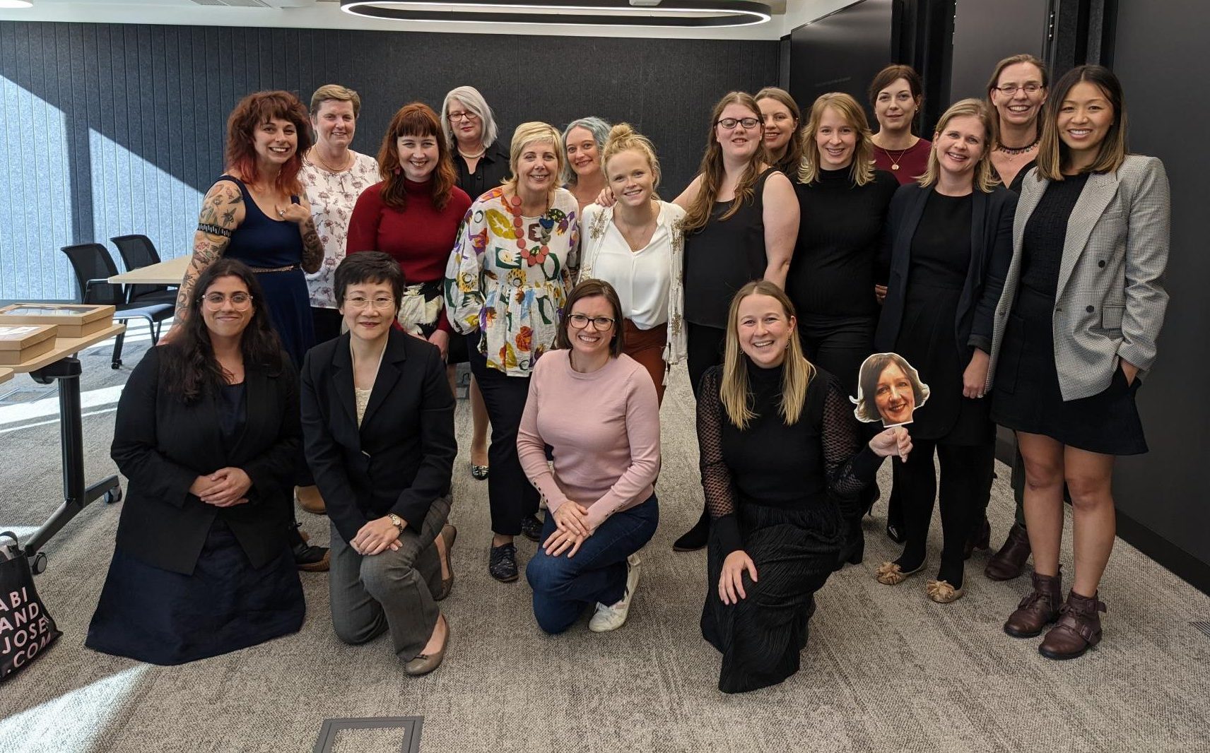The Australian Network on Disability team. 18 women in corporate attire standing together, smiling.